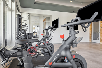 A peloton bike is in a modern, spacious room.